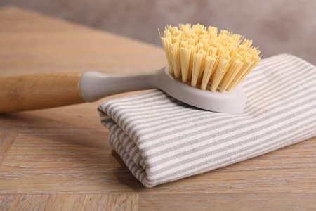 One cleaning brush and rag on wooden table, closeup