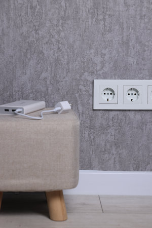 Electric power sockets on gray wall indoors