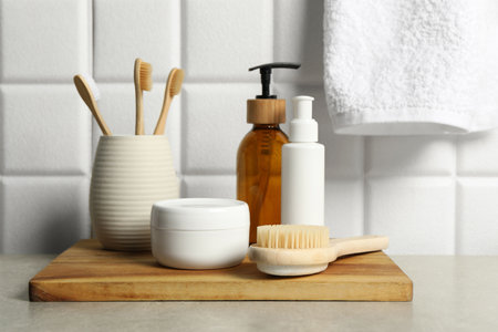 Different bath accessories and personal care products on gray table near white tiled wallの写真素材