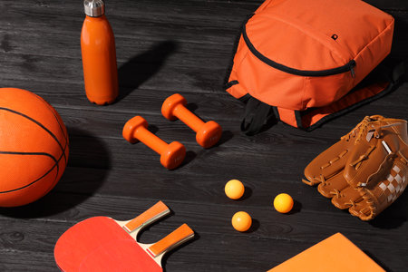 Many different sports equipment on dark gray wooden tableの写真素材