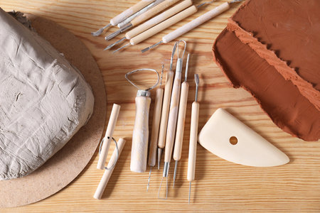 Clay and set of modeling tools on wooden table, flat layの写真素材