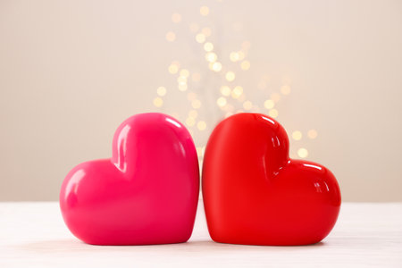 Composition with ceramic hearts on white table against blurred lightsの写真素材