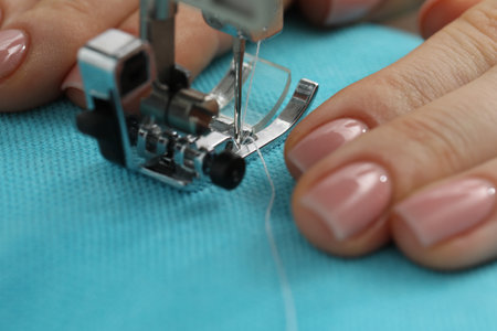 Seamstress working with sewing machine, selective focus