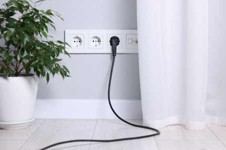 Power sockets and electric plug on gray wall