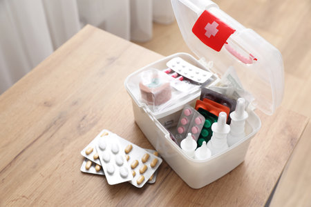 First aid kit and medicines on wooden table indoors, space for textの写真素材