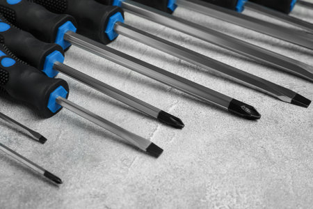 Set of screwdrivers on gray textured table, closeup
