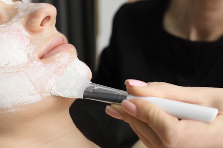 Cosmetologist applying mask on woman's face, closeupの写真素材