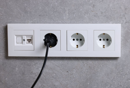 Power sockets and electric plug on gray wallの写真素材