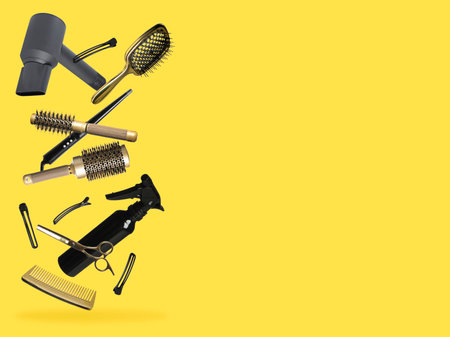 Professional hairdresser tools falling on golden background, space for textの写真素材