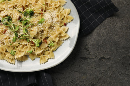 Vegetarian meal. Tasty pasta with fresh vegetables and cheese on gray table, top view. Space for textの写真素材