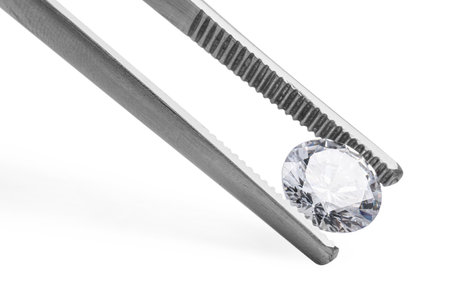 Tweezers with beautiful shiny diamond isolated on whiteの写真素材