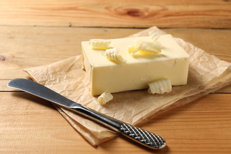 Tasty butter and knife on wooden tableの写真素材