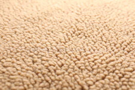 Texture of light brown faux fur as background, closeup