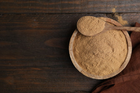 Dietary fiber. Psyllium husk powder in bowl and spoon on wooden table, top view. Space for textの写真素材