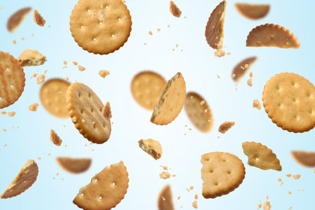 Tasty dry crackers falling on light blue backgroundの写真素材