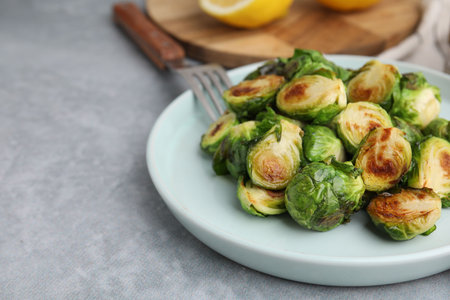 Delicious roasted Brussels sprouts on gray table, closeup. Space for textの写真素材