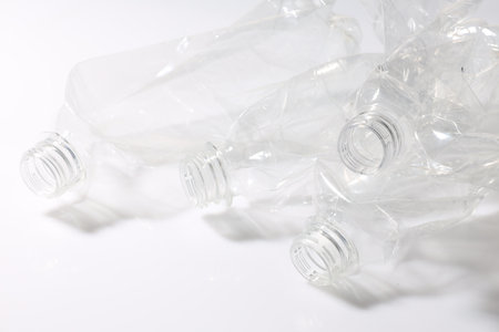 Crumpled disposable plastic bottles on white backgroundの写真素材