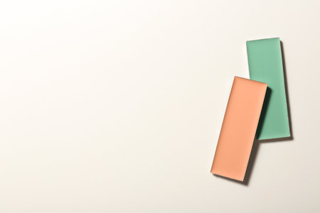 Different color correcting concealers on white background, top view