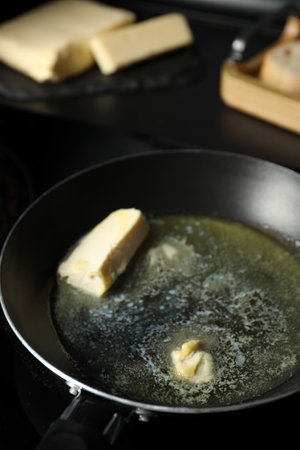 Melting butter in frying pan on tableの写真素材