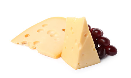 Pieces of delicious cheese and grapes isolated on whiteの写真素材