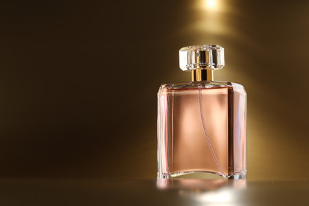 Luxury women's perfume. Sunlit glass bottle on golden background, space for textの写真素材
