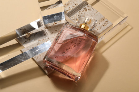 Stylish presentation of luxury women`s perfume in sunlight on beige backgroundの写真素材