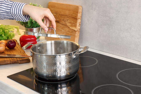 Woman cooking dinner on cooktop in kitchen, closeupの写真素材