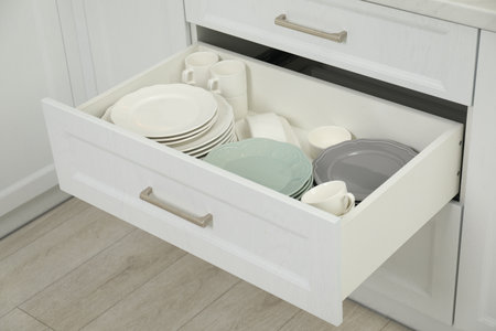 Clean plates, cups and bowls in drawer indoors