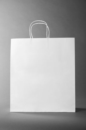 One white paper bag on gray background. Mockup for designの写真素材