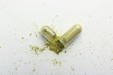 Broken light green vitamin capsule on white background, top viewの写真素材