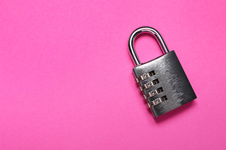 One steel combination padlock on pink background, top view. Space for textの写真素材