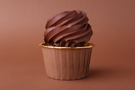 Delicious chocolate cupcake on brown background, closeupの写真素材