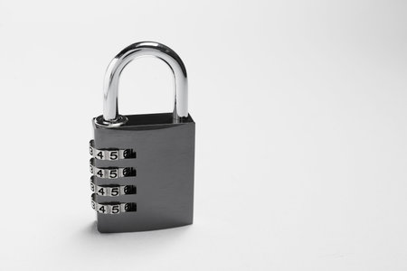 One steel combination padlock on gray background. Space for text