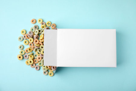 Paper box with tasty cereal rings on light blue background, flat layの写真素材