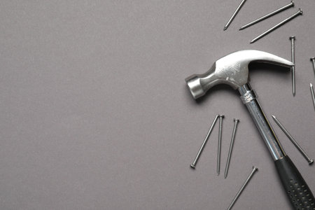 Hammer and metal nails on gray background, top view. Space for textの写真素材