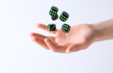 Woman throwing game dices on white background, closeup
