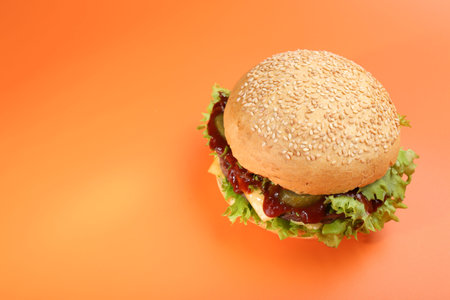 Delicious cheeseburger on coral background, above view. Space for textの写真素材