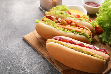 Delicious hot dogs with different toppings served on gray table. Space for textの写真素材