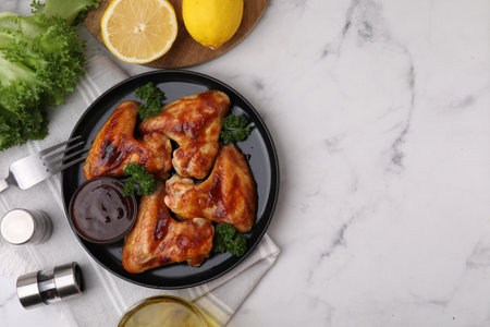 Flat lay composition with marinade and chicken wings on white marble table. Space for textの写真素材