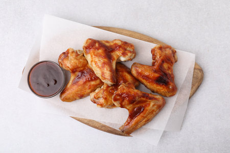 Board with marinade and chicken wings on light table, top viewの写真素材