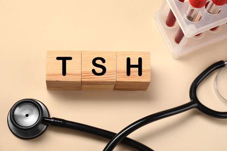 Endocrinology. Stethoscope, wooden cubes with thyroid hormones and blood samples in test tubes on...