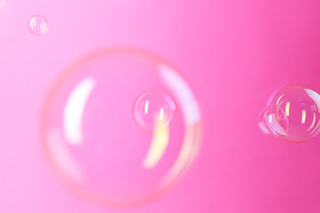 Beautiful transparent soap bubbles on pink backgroundの写真素材