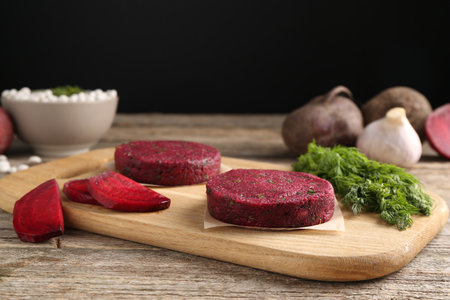 Vegetarian product. Uncooked beetroot cutlets and ingredients on wooden tableの写真素材