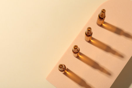 Glass ampoules with liquid on beige background, top view. Space for textの写真素材