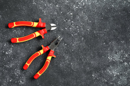 Pliers on black textured table, flat lay. Space for textの写真素材