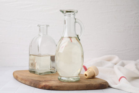 Vinegar in glass jug and bottle on white tableの写真素材