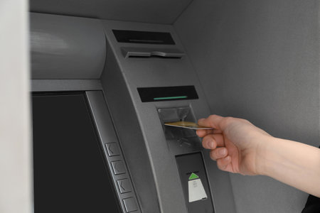 Woman inserting credit card into cash machine outdoors, closeupの写真素材