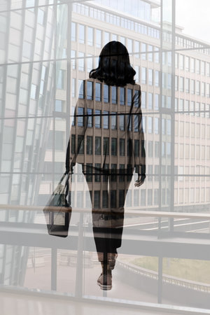 Double exposure of businesswoman and cityscape with office buildingsの写真素材