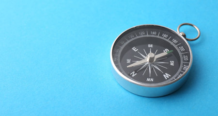 One compass on light blue background, closeup. Space for textの写真素材