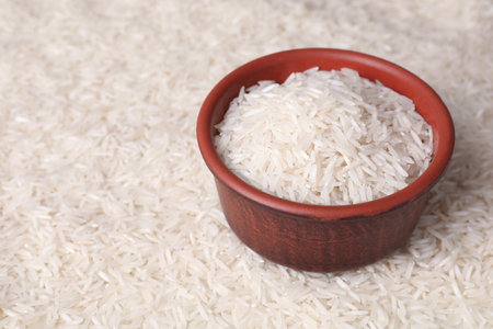 Raw basmati rice and bowl as background, closeup. Space for textの写真素材